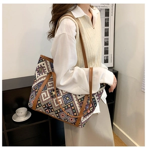 Detail of a vintage colorful woven tote bag with geometric diamond patterns and leather handles