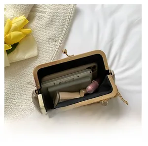 Interior view of beige vintage kiss-lock bag showing capacity for phone and lipstick