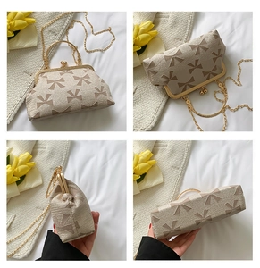 Detail view of cream vintage jacquard bag with bow pattern and gold ring handle