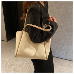 Detail of large tote bag with silk scarf decoration and brown leather trim accents