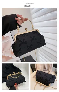 Detail of vintage black satin evening bag with metal frame and floral handle accents