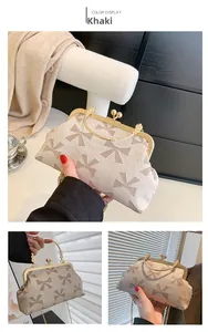 Detailed close-up of khaki clutch bag with bow patterns and gold ring handle