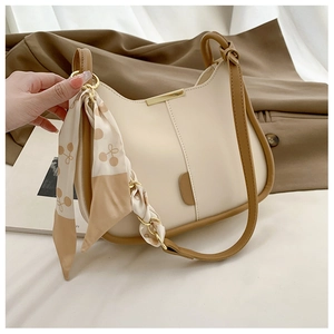 Détail du sac seau crème avec bordure marron et foulard en soie motif cerise
