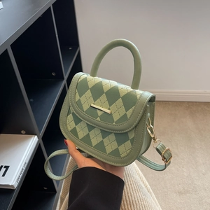 Green quilted crossbody saddle bag with gold metal trim and arc handle for women