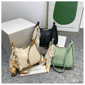 Détail de grands sacs seaux en trois couleurs avec des foulards en soie décoratifs chic