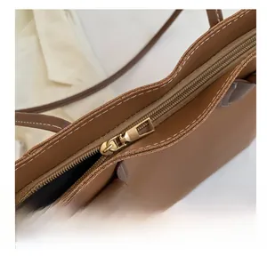 Detail view of smooth golden zipper and premium synthetic leather texture on tote bag