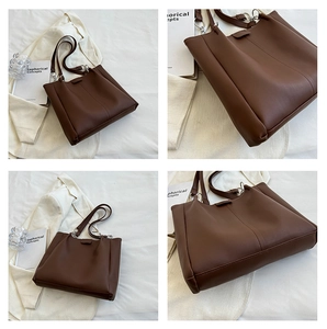 Detail view of large dark brown leather tote bag with silver rings and stylish stitching
