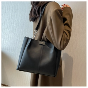 Detail of black PU leather tote bag with lychee texture and silver metal rings