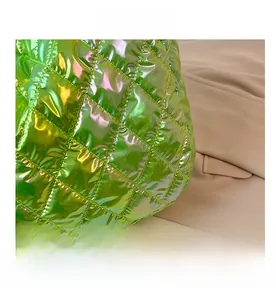 Detailed macro view of vibrant green metallic quilted fabric with laser finish and rhombic pattern
