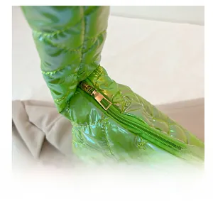 Detail of metallic green quilted tote bag featuring a smooth gold metal zipper and puller