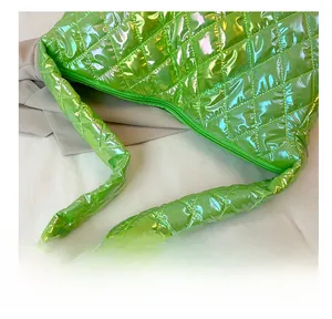 Detail of bright green quilted tote bag with metallic finish and comfortable wide handle