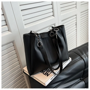 Detail of black leather tote bag with silver metal ring straps for urban commuting