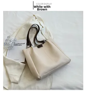Detail of minimalist tote bag in creamy white and brown straps with silver metal rings
