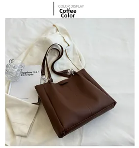 Detail view of coffee brown faux leather tote bag with vertical stitching on white fabric