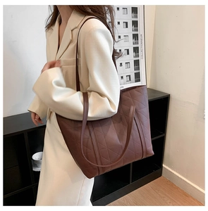 Detail of a dark brown quilted tote bag showing large capacity and rhombic stitching texture