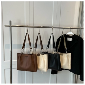 Detailed display of large PU leather tote bags with metal chain straps and ribbed texture