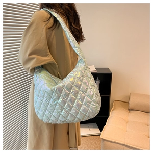 Close-up of holographic quilted tote bag featuring a glossy iridescent finish and wide strap