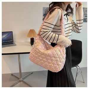 Detailed view of pink quilted tote bag with holographic finish worn by a model