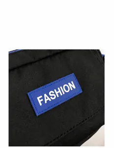 Detail einer schwarzen Segeltuchtasche mit blauem Fashion-Silikonetikett und Gewebestruktur