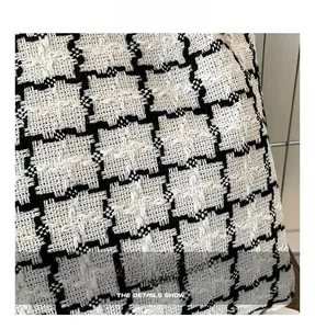 Close-up of black and white checkered tweed fabric with high-quality woven texture