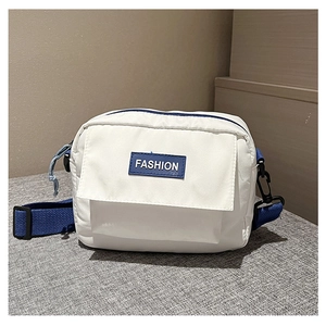Detalle de bandolera de lona blanca con cremallera azul y parche de Fashion