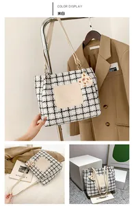 Detail of checkered tote bag with tiger charm and beige leather pocket display