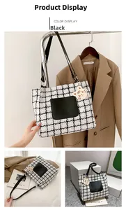 Detailed view of plaid tote bag featuring a leather pocket and tiger charm accessory