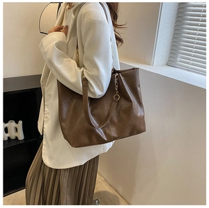 Sac cabas en cuir marron avec blazer blanc et détail de chaîne pour un look professionnel