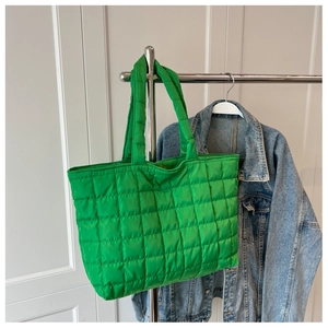 Close-up of bright green quilted nylon tote bag showing detailed square stitching
