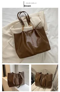Détail du sac cabas marron en cuir texturé avec chaîne dorée et finition souple