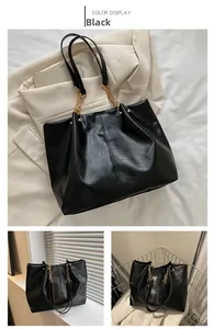 Détail d'un grand cabas noir en similicuir souple avec bandoulière à chaîne dorée chic