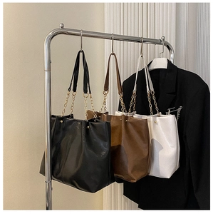 Trois grands sacs cabas en noir marron et blanc dotés de bandoulières avec chaîne dorée chic