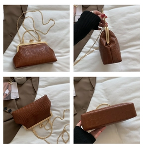 Detail view of brown crocodile texture bag with gold metal frame and handle