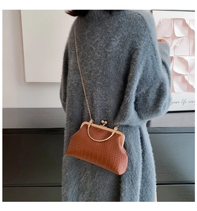 Brown crocodile pattern vintage doctor bag with chain strap shown on model in retro setting