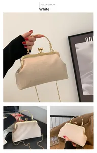 Detail of white crocodile embossed leather handbag with vintage gold metal handle and clasp