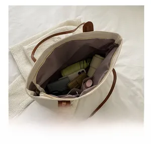 Internal view of large beige tote bag showing spacious compartments and brown lining