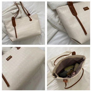 Detail view of large white tote bag featuring diamond texture and spacious interior