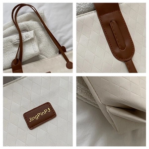 Detailed close-up of diamond-quilted faux leather tote with brown handles and precision stitching