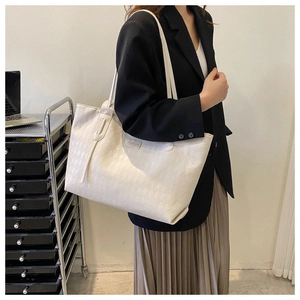 Detailed view of cream white tote bag featuring woven texture and spacious interior