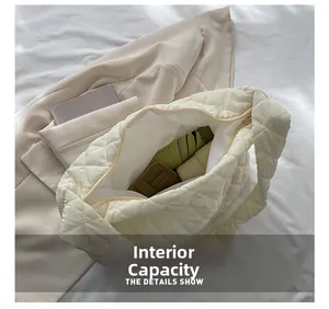 Internal capacity of the off-white quilted puffer bag holding a wallet and umbrella