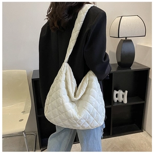 Detail of white quilted nylon tote bag with rhombus stitching and wide shoulder strap