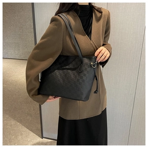 Close-up of black tote bag featuring elegant checkerboard texture and side drawstring