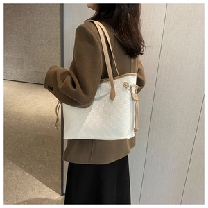 Detail of woven texture and contrast drawstrings on a large capacity white tote bag