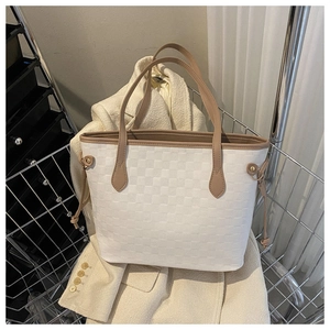 Detail of white woven tote bag with brown straps and drawstring tassels for commuting
