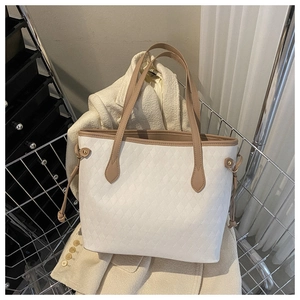 Close-up of beige tote bag with diamond quilted texture and brown leather straps