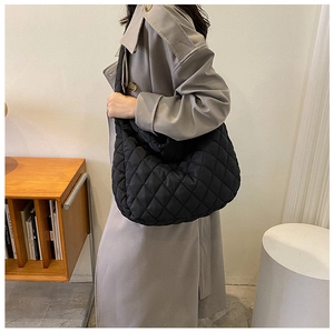Detail of black quilted nylon puffer bag showing soft texture and spacious slouchy design