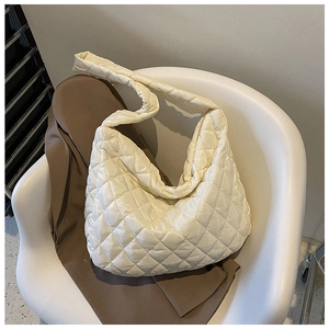 Close-up of quilted beige nylon hobo bag featuring diamond stitching and padded texture