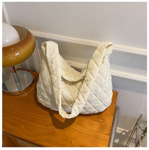 Detail of cream white quilted puffy tote bag with classic diamond stitch patterns