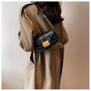 Close-up of black stone pattern crossbody bag with gold lock and chain strap detail