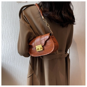 Detail of dark brown faux-crocodile bag featuring vintage gold buckle and chain strap